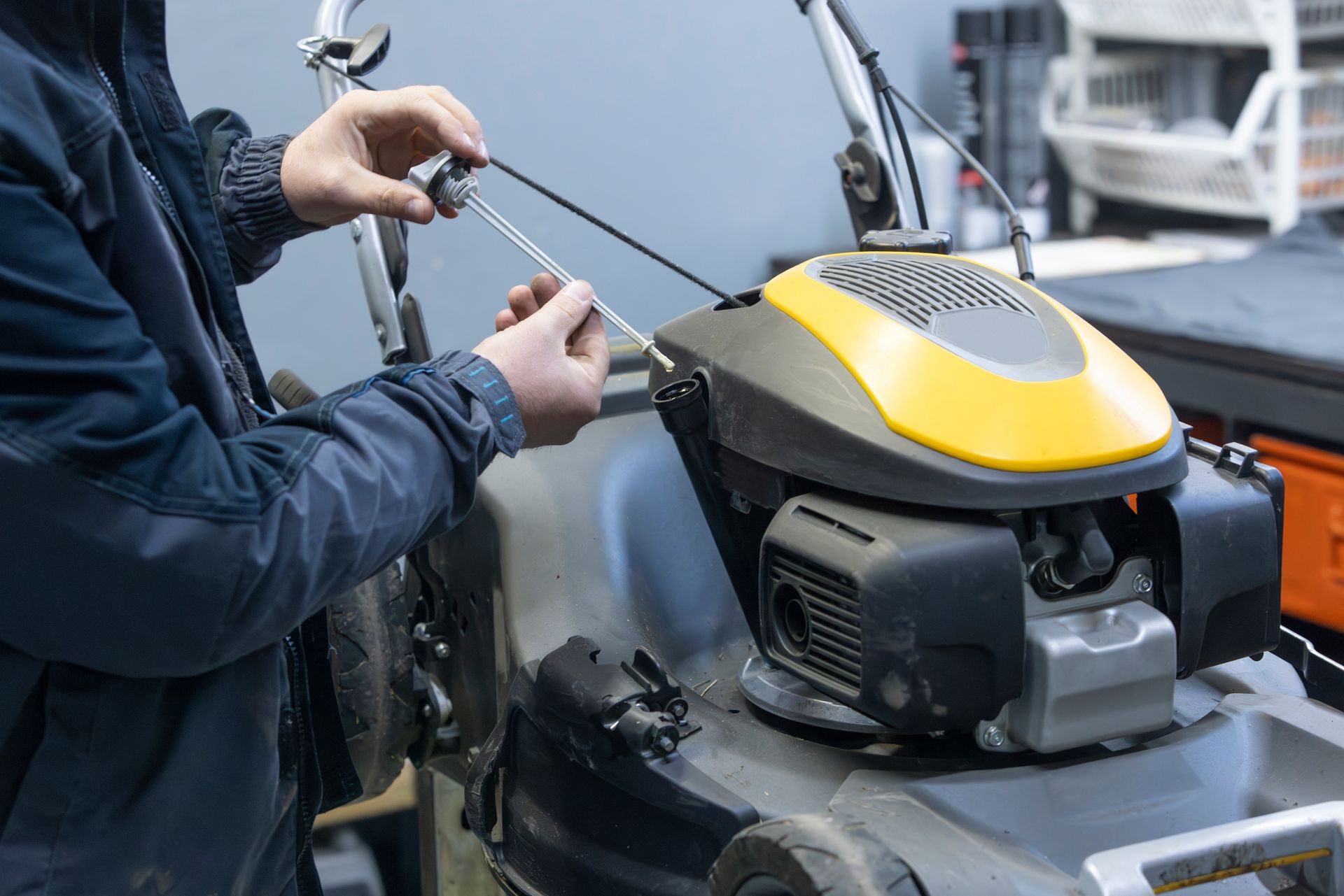 Une personne ajuste les commandes d'un moteur hors-bord jaune et gris près de l'eau.