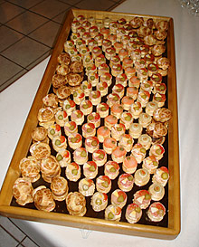 Un plateau en bois rempli de beaucoup de nourriture sur une table