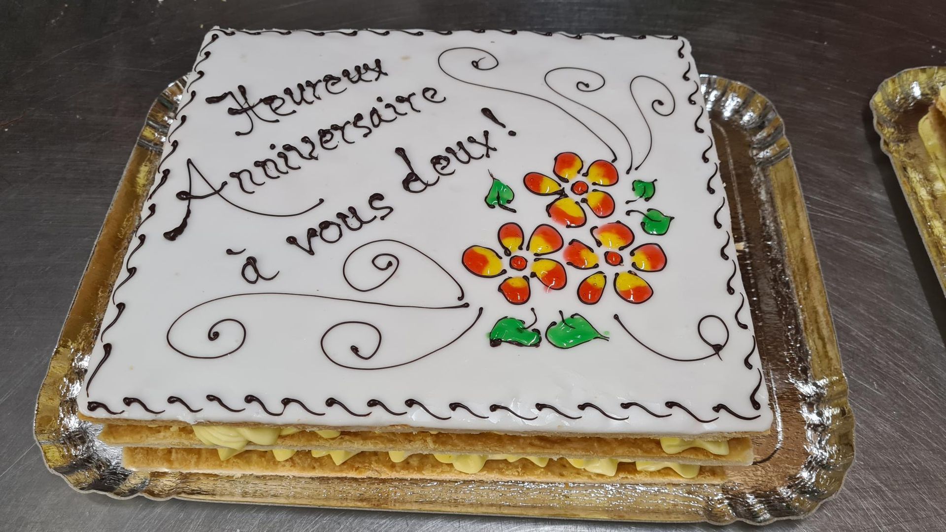 A cake on a tray that says anniversaire a vous doux