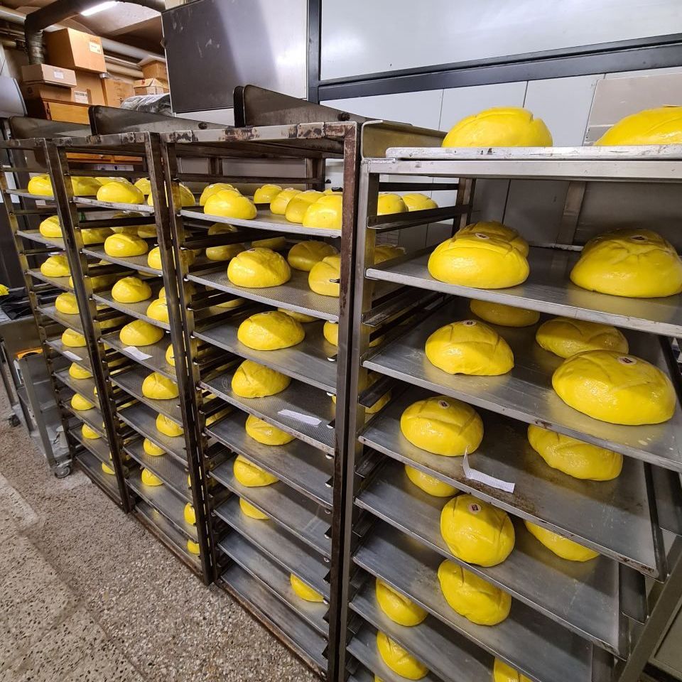 Un tas de pain jaune sur une étagère dans une boulangerie Boulangerie – Tea-Room Les Arcades