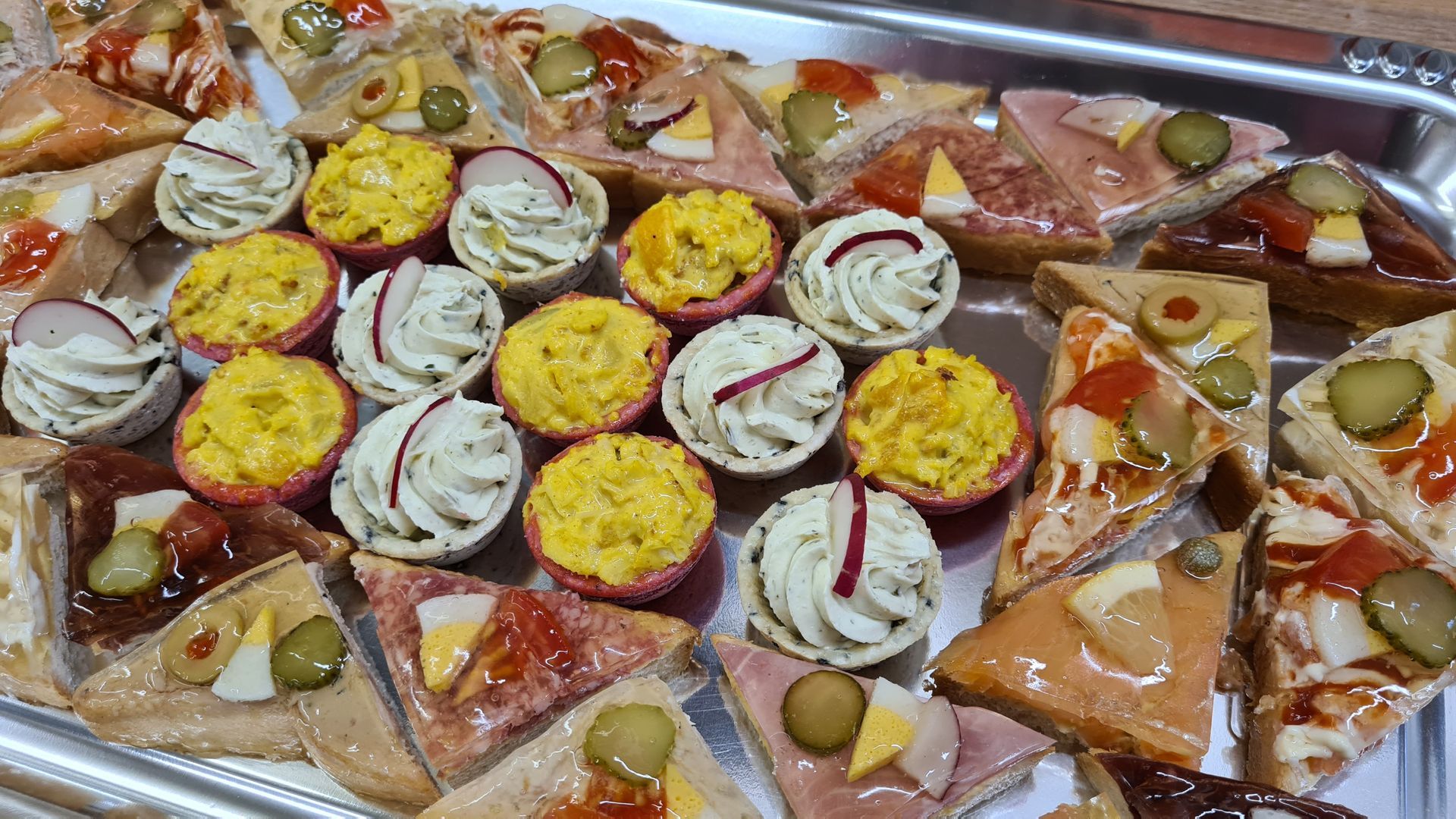 Il y a de nombreux types d'aliments différents sur le plateau Boulangerie – Tea-Room Les Arcades