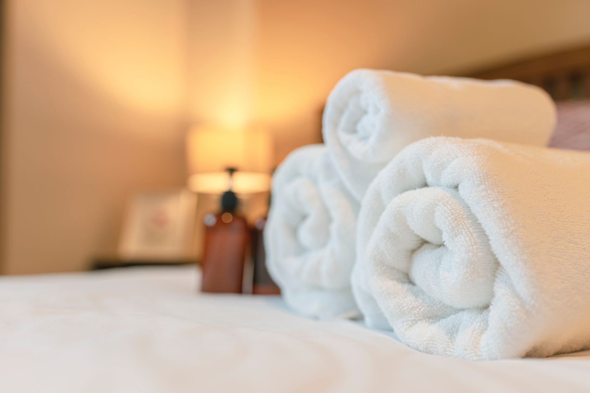 Serviettes de bain roulées sur un lit