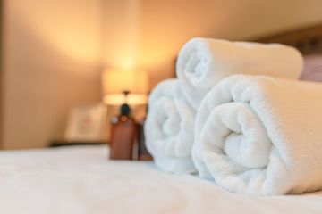 Serviettes de bain roulées sur un lit