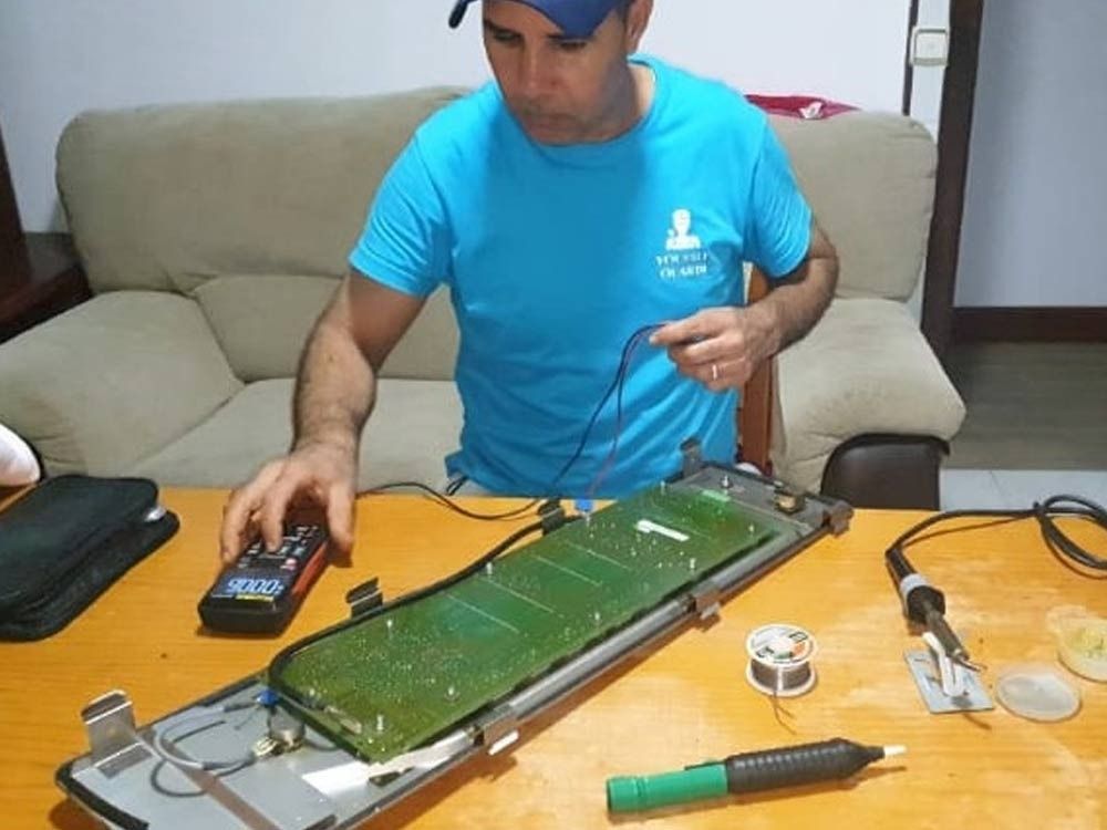 Un hombre con una camisa azul está trabajando en una computadora.