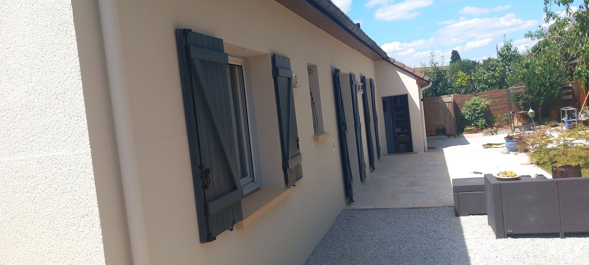 Une façade de maison avec des menuiseries grises.