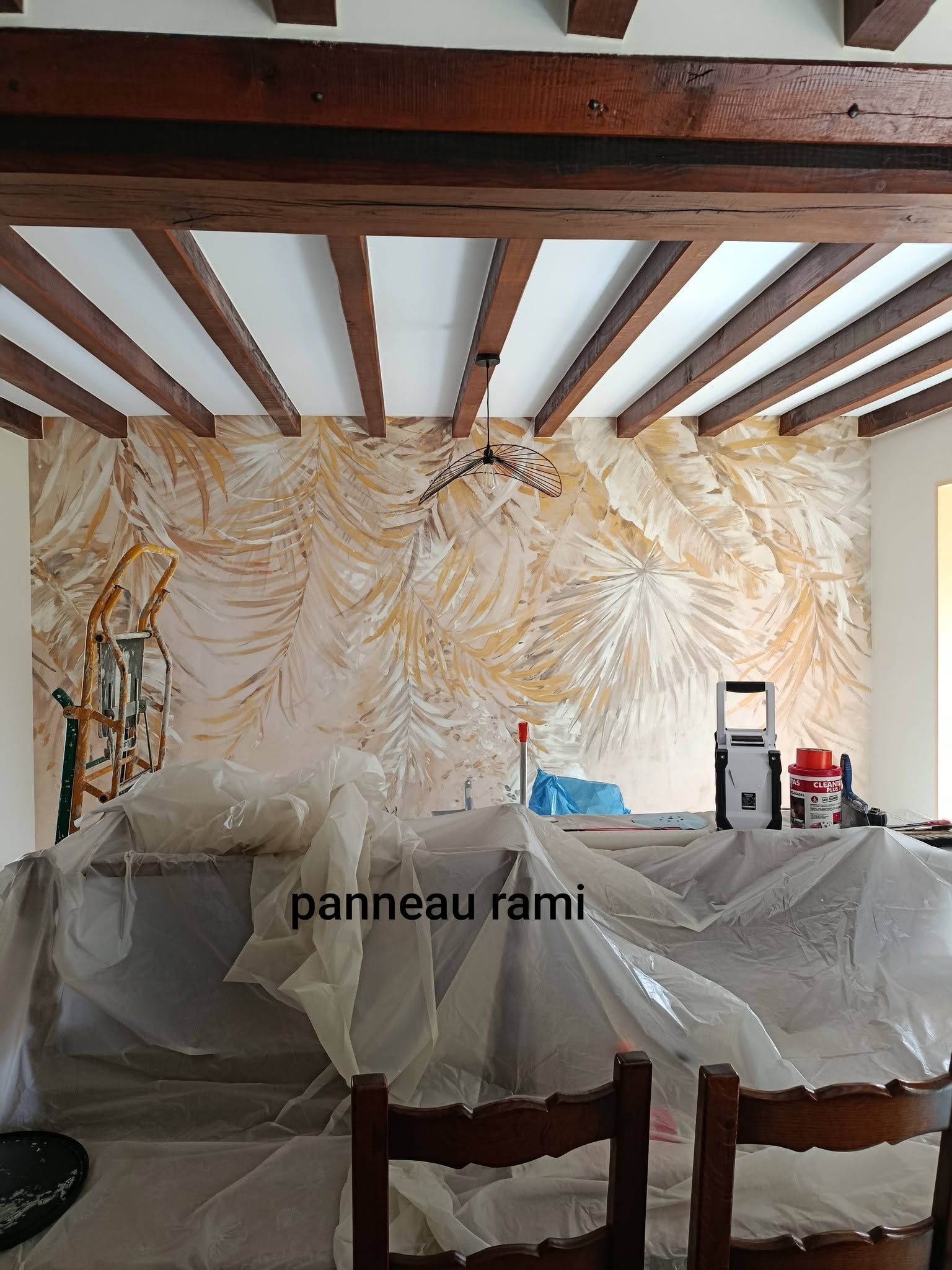 Une pièce en cours de rénovation avec un papier peint panoramique au mur.