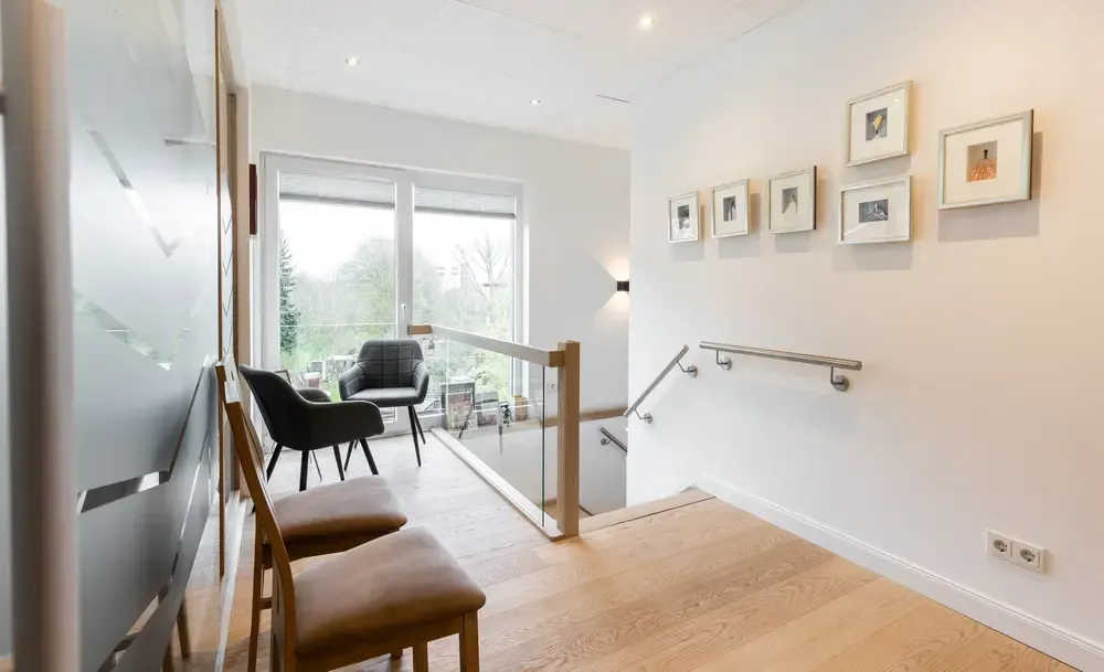Ein Flur mit Stühlen und einer Treppe in einem Haus.