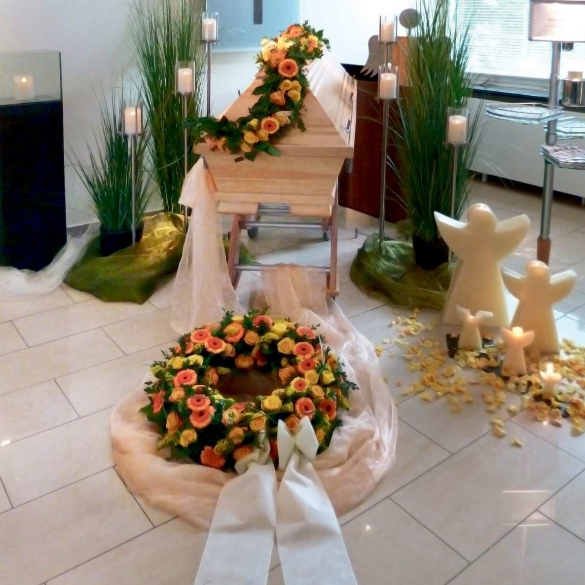 Ein Raum mit einem Sarg und einem Blumenkranz