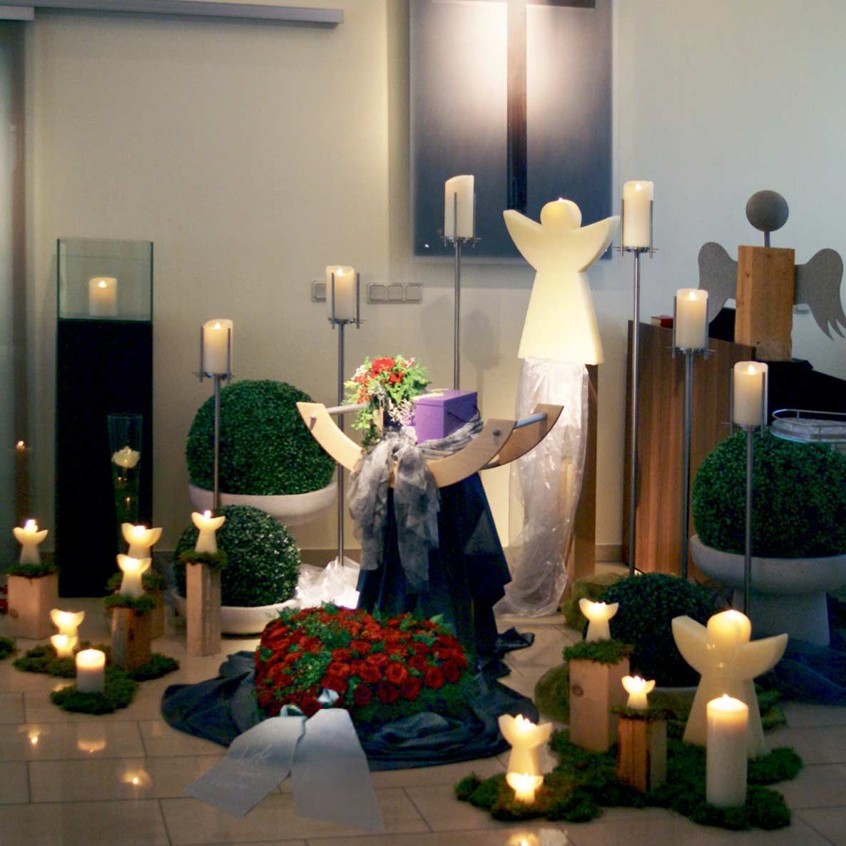 Ein Raum mit vielen Kerzen und Blumen