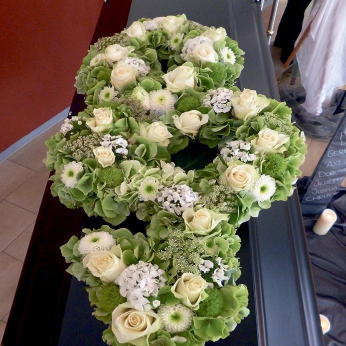 Ein Kranz aus grünen und weißen Blumen in der Form der Zahl 8
