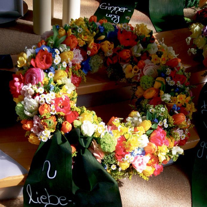 Ein Blumenkranz mit einer grünen Schleife mit der Aufschrift „Liebe“