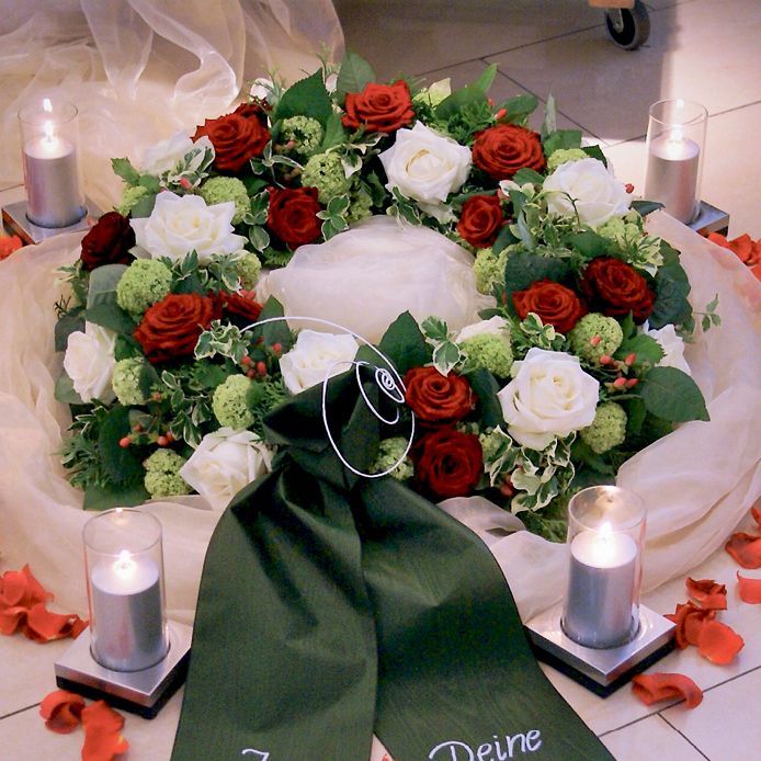 Ein Blumenkranz mit einer grünen Schleife mit der Aufschrift „Deine“