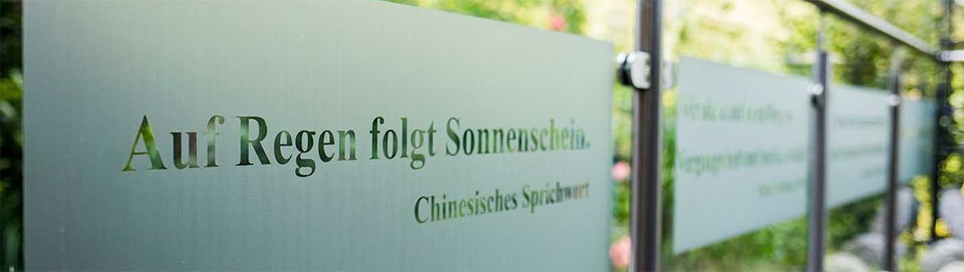 Eine Reihe von Milchglasschildern mit deutscher Schrift darauf.