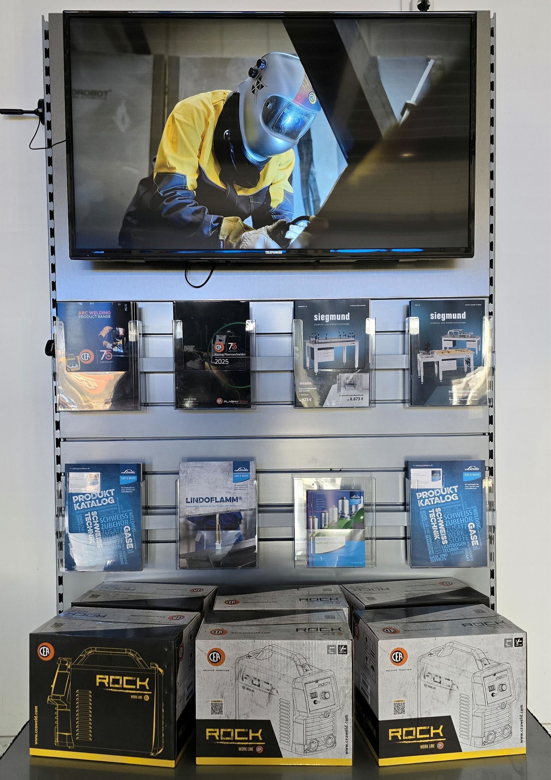 Eine Person schweißt Metall mit Funken und hellblauem Licht.