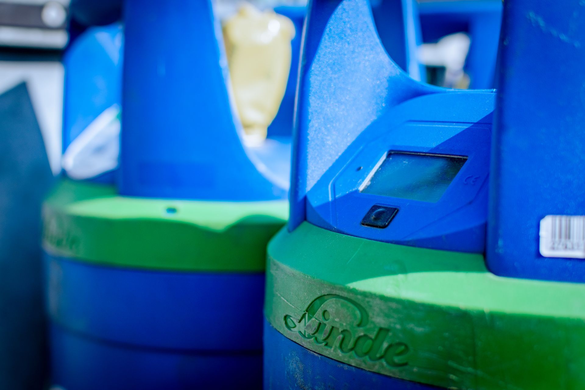 Schweißer mit Maske arbeitet an Metall, Funken fliegen in einer dunklen Werkstatt.