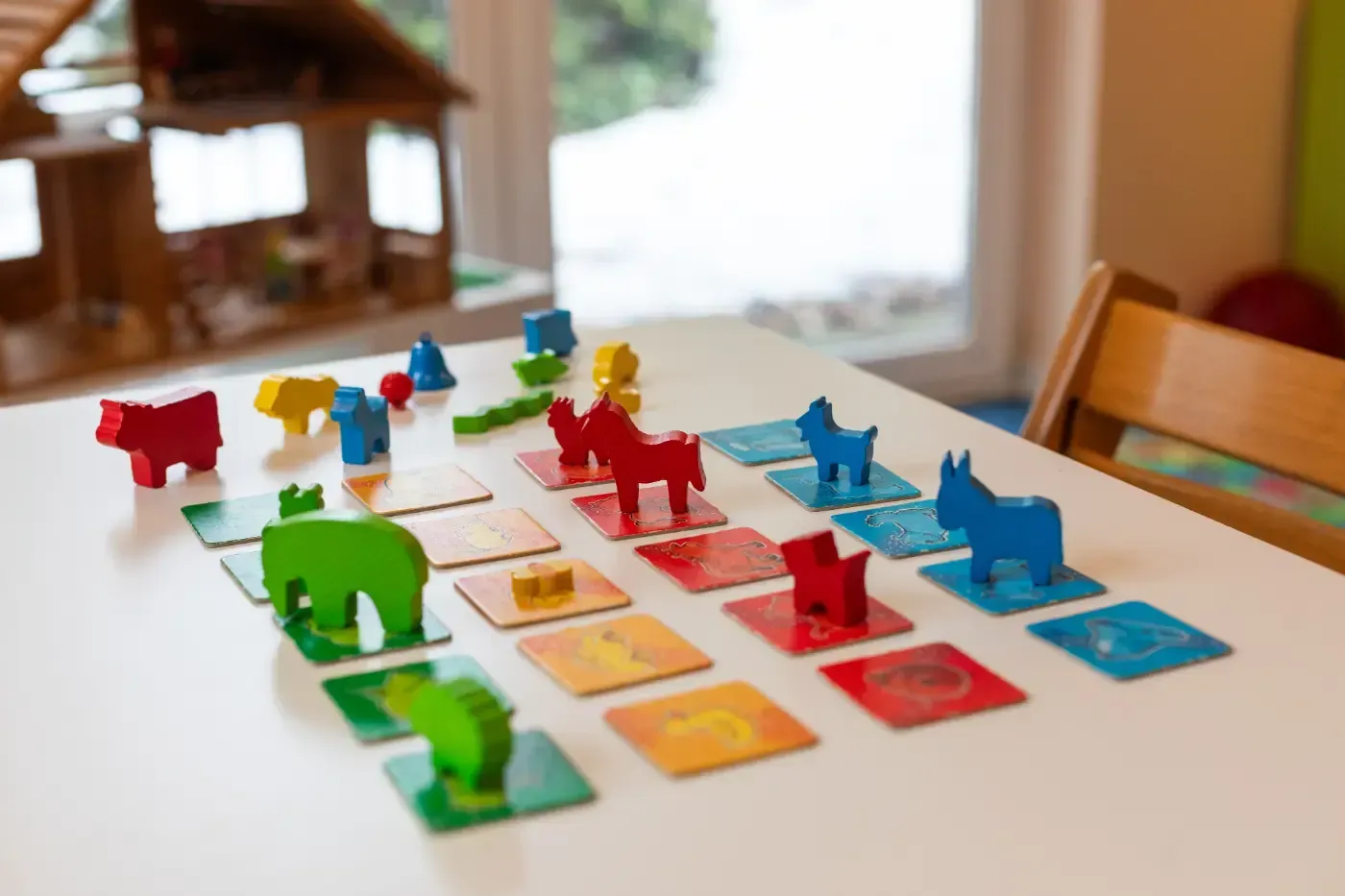 Bunte Brettspielfiguren und Karten sind auf einem Tisch im Innenbereich angeordnet.