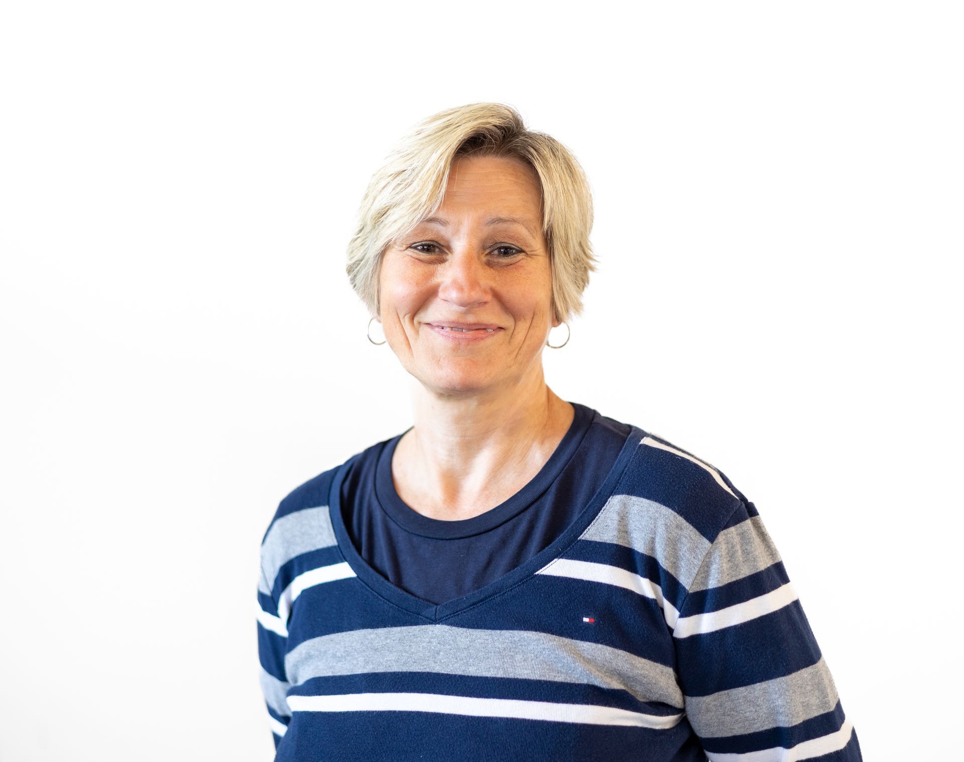 Eine Frau in einem blau - grau gestreiften Pullover lächelt in die Kamera.