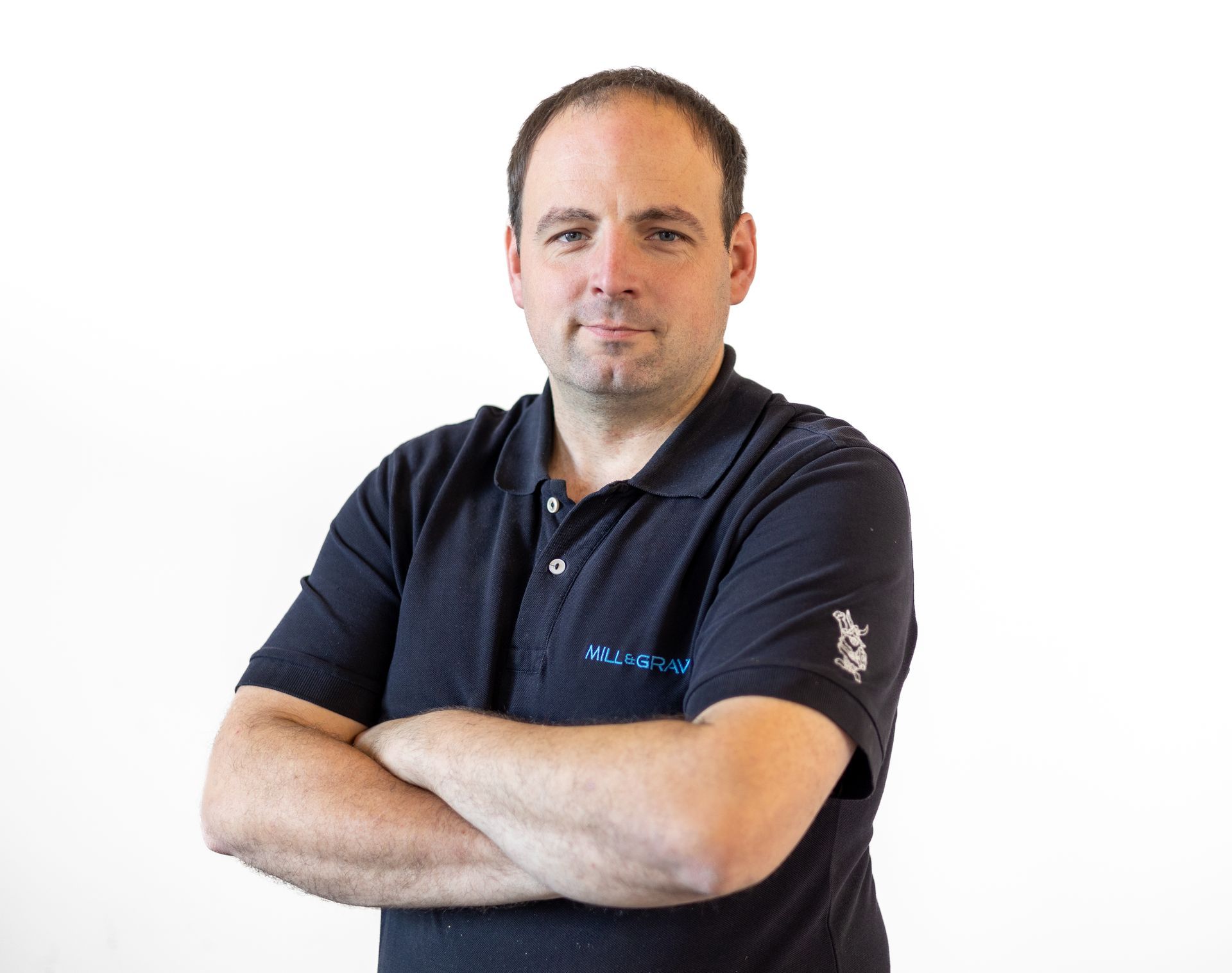 Ein Mann in einem schwarzen Poloshirt mit verschränkten Armen