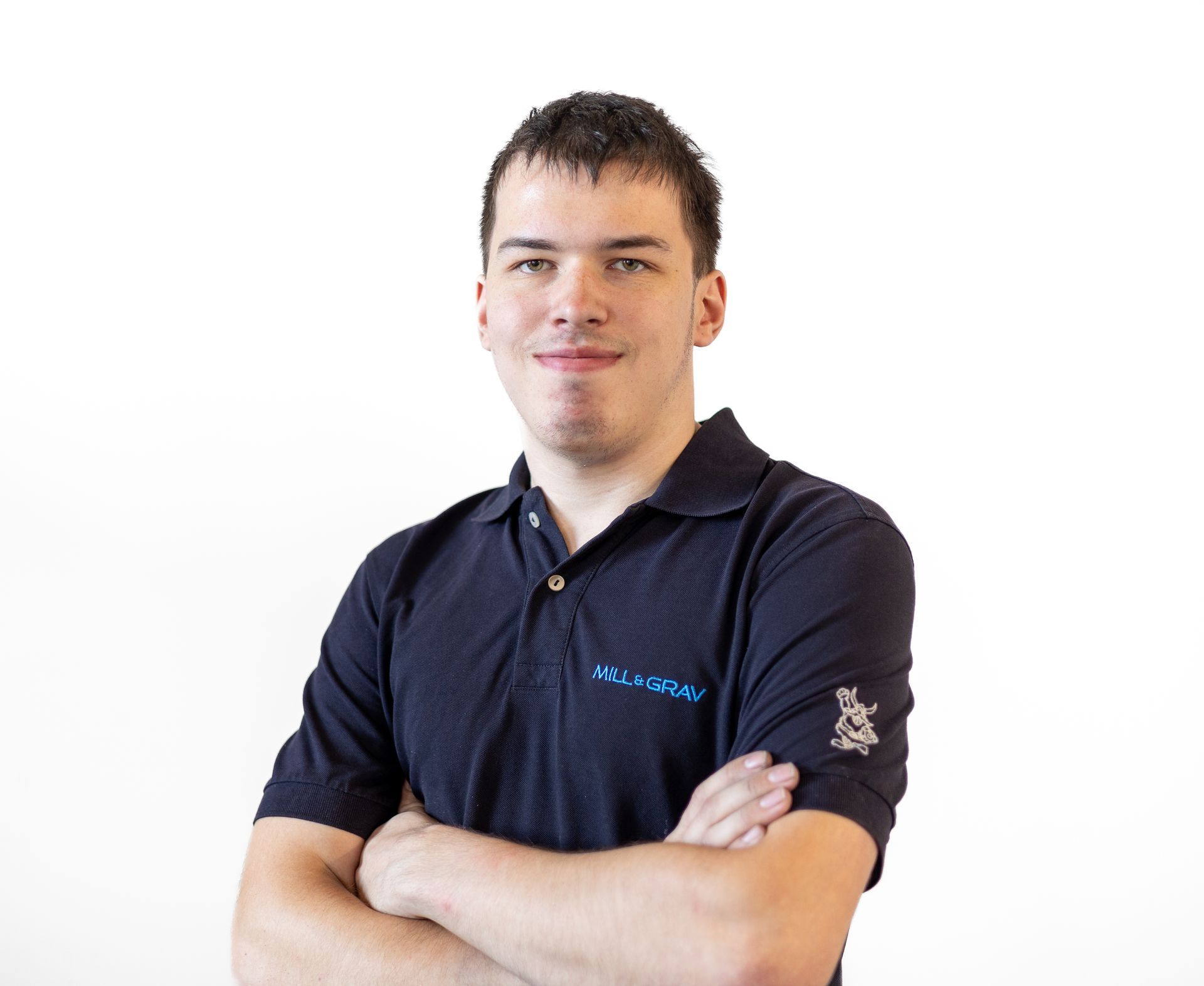 Ein junger Mann mit verschränkten Armen und einem schwarzen Poloshirt