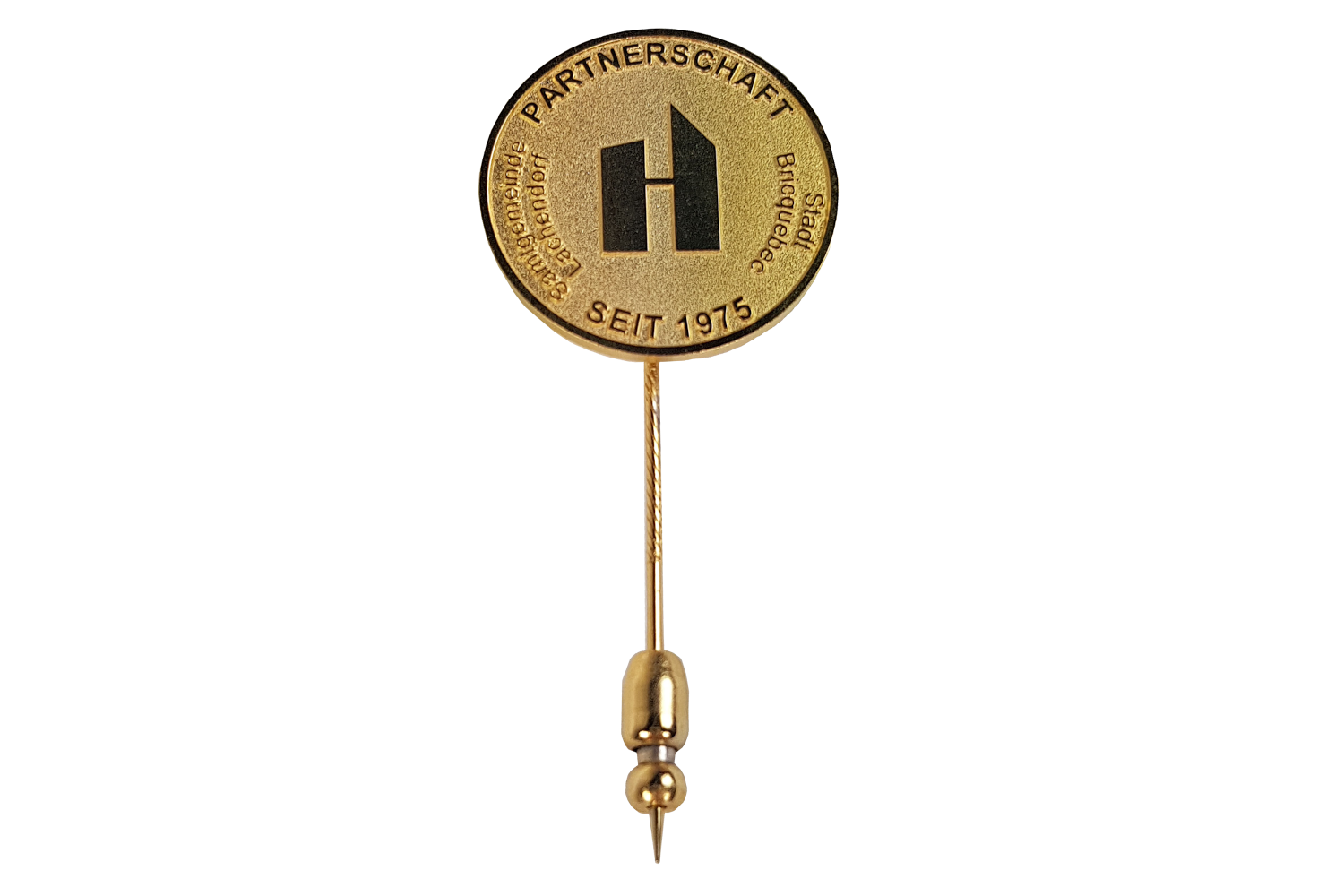 Eine goldene Anstecknadel mit dem Buchstaben H darauf