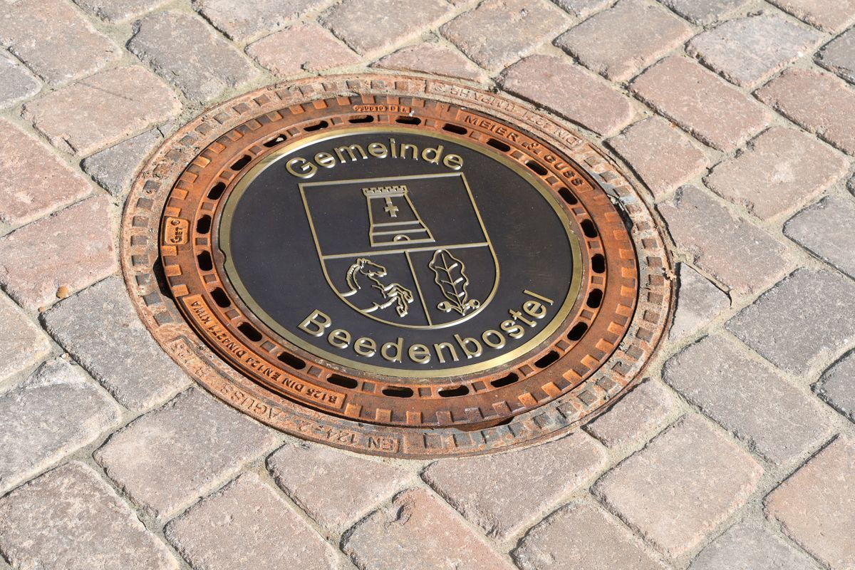 Ein Kanaldeckel mit einem Wappen darauf