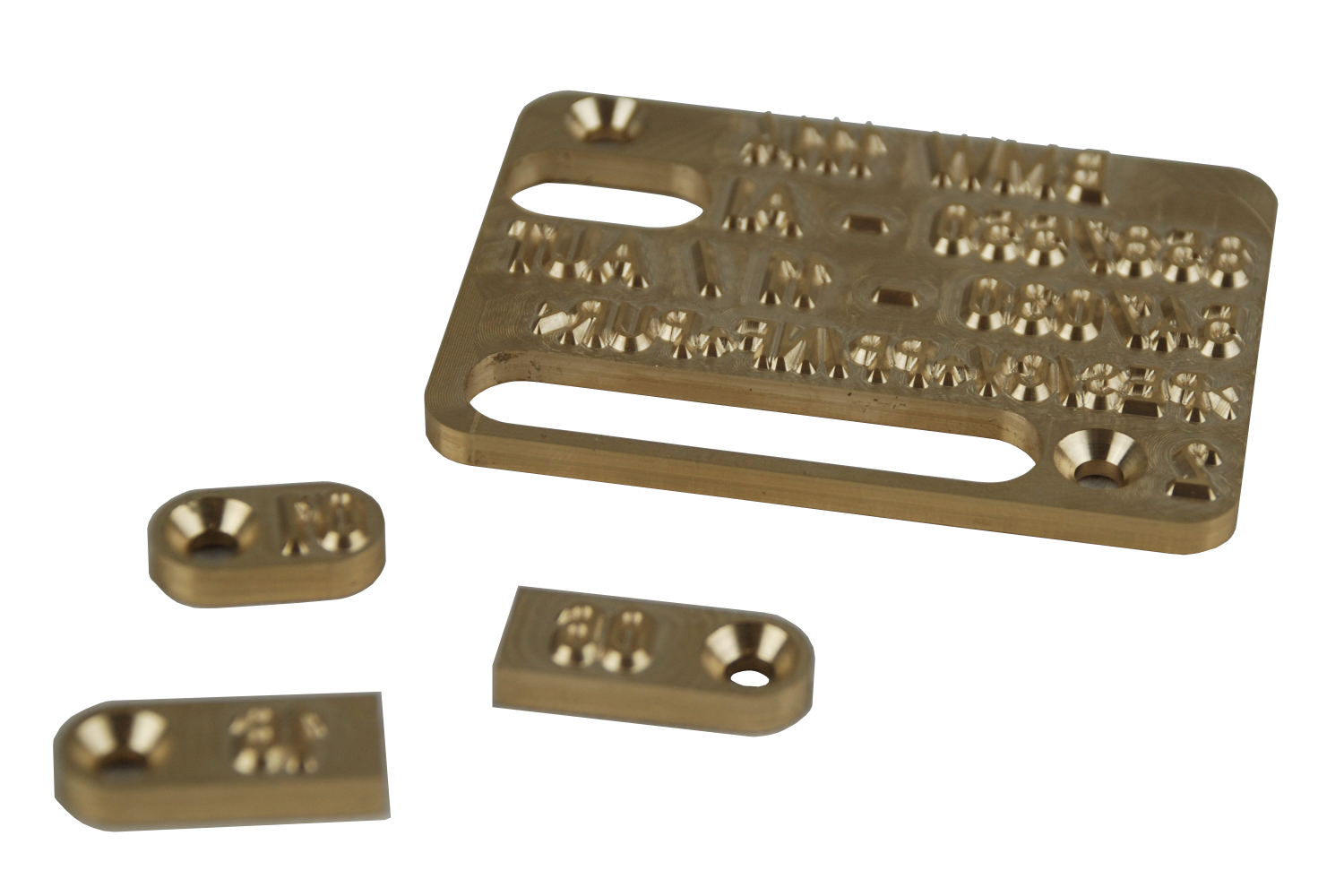 Drei Messingstücke liegen nebeneinander auf einer weißen Fläche.