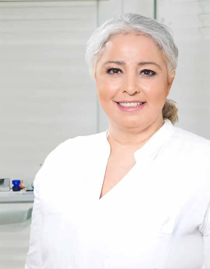 Eine Frau in einem weißen Hemd lächelt in die Kamera.