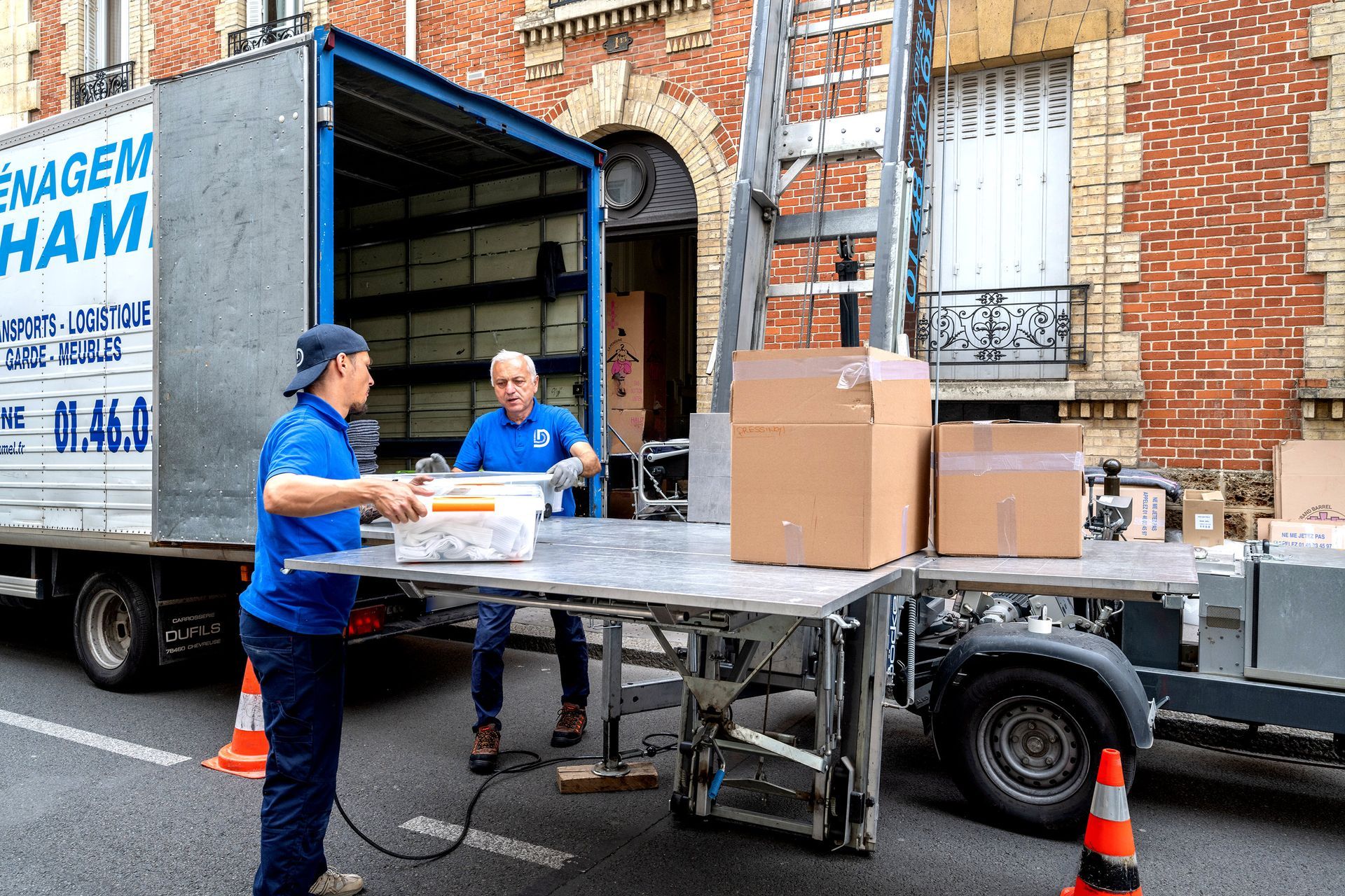 Professionnels de l'entreprise récupérant les cartons du monte-charge pour les mettre dans le camion