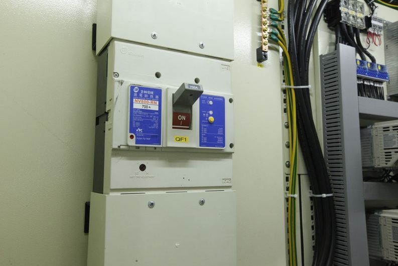 Una caja eléctrica blanca con un interruptor rojo.