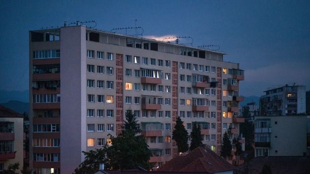 Un edificio alto con muchas ventanas está iluminado por la noche.