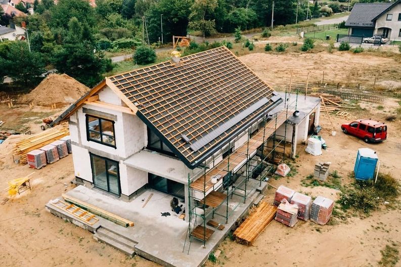 Una vista aérea de una casa en construcción en un campo de tierra.