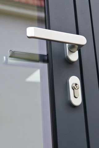 Gros plan sur la poignée d'une porte vitrée.
