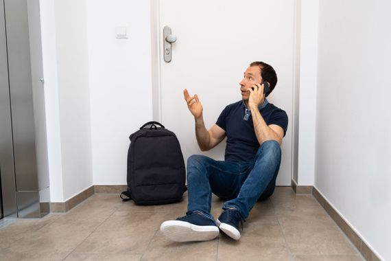 Gros plan sur une main tenant une clé cassée près d'un cylindre de serrure de porte.