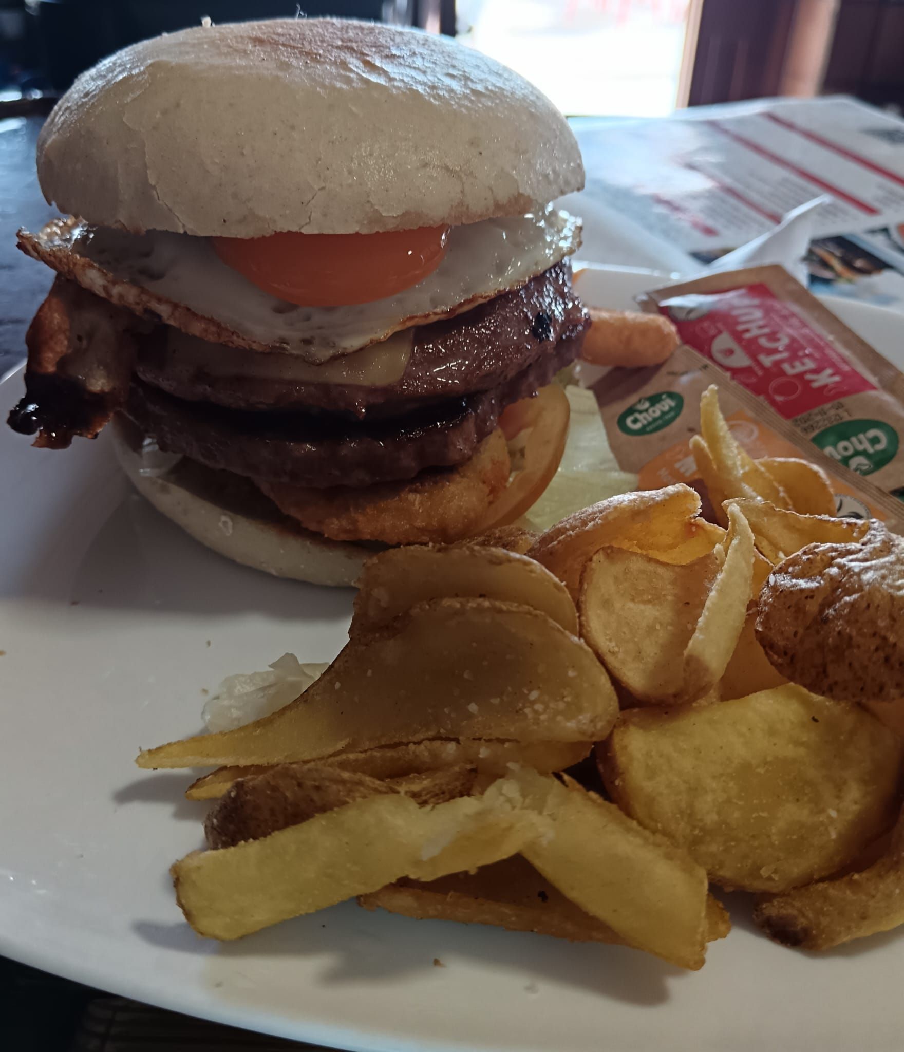 Una hamburguesa y papas fritas en un plato blanco.