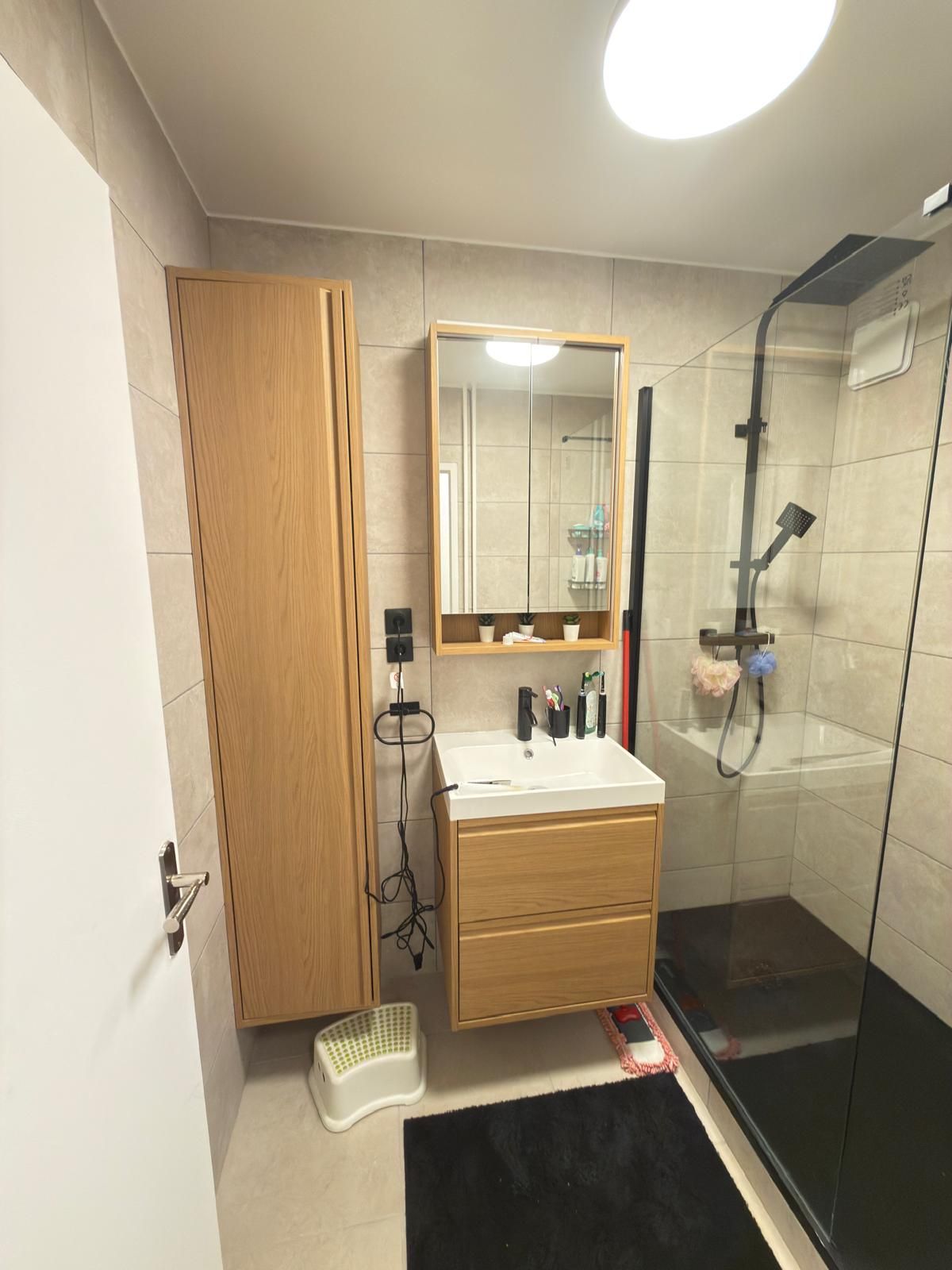 Petite salle de bains moderne avec meuble de lavabo en bois, armoire haute et douche à l'italienne.