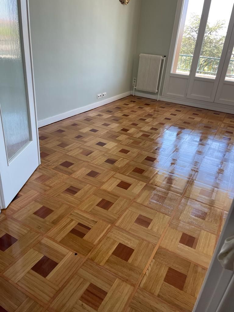 Sol en parquet dans une pièce aux murs vert clair.