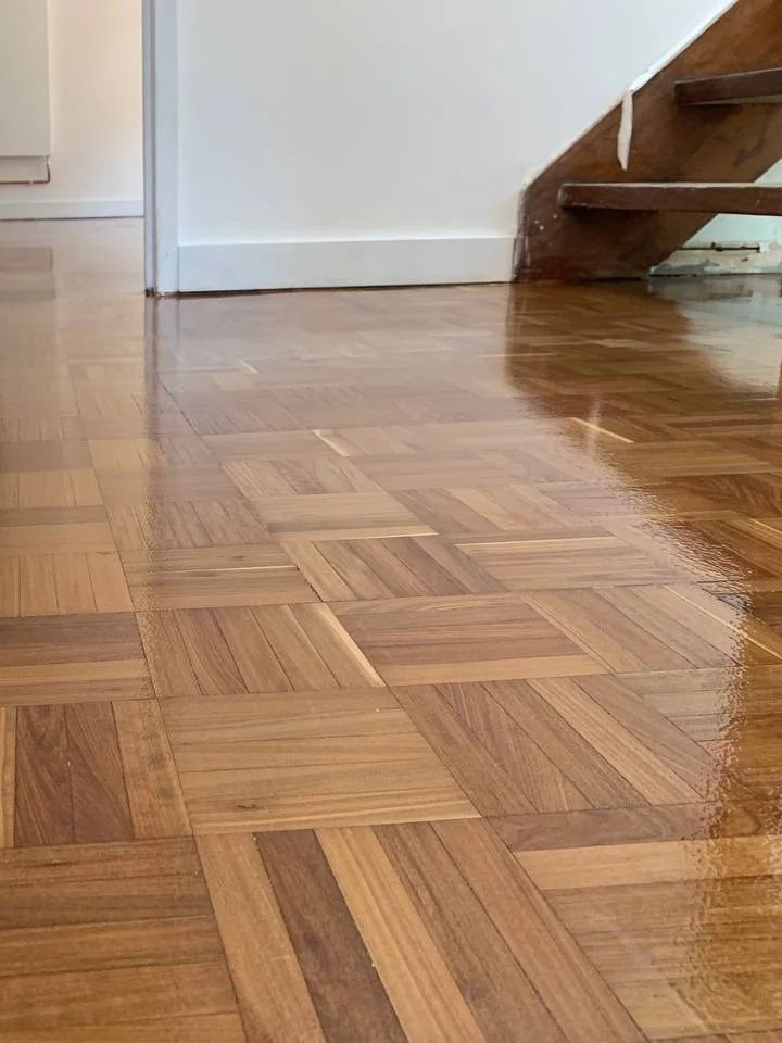 Parquet brillant avec escalier en bois en arrière-plan.