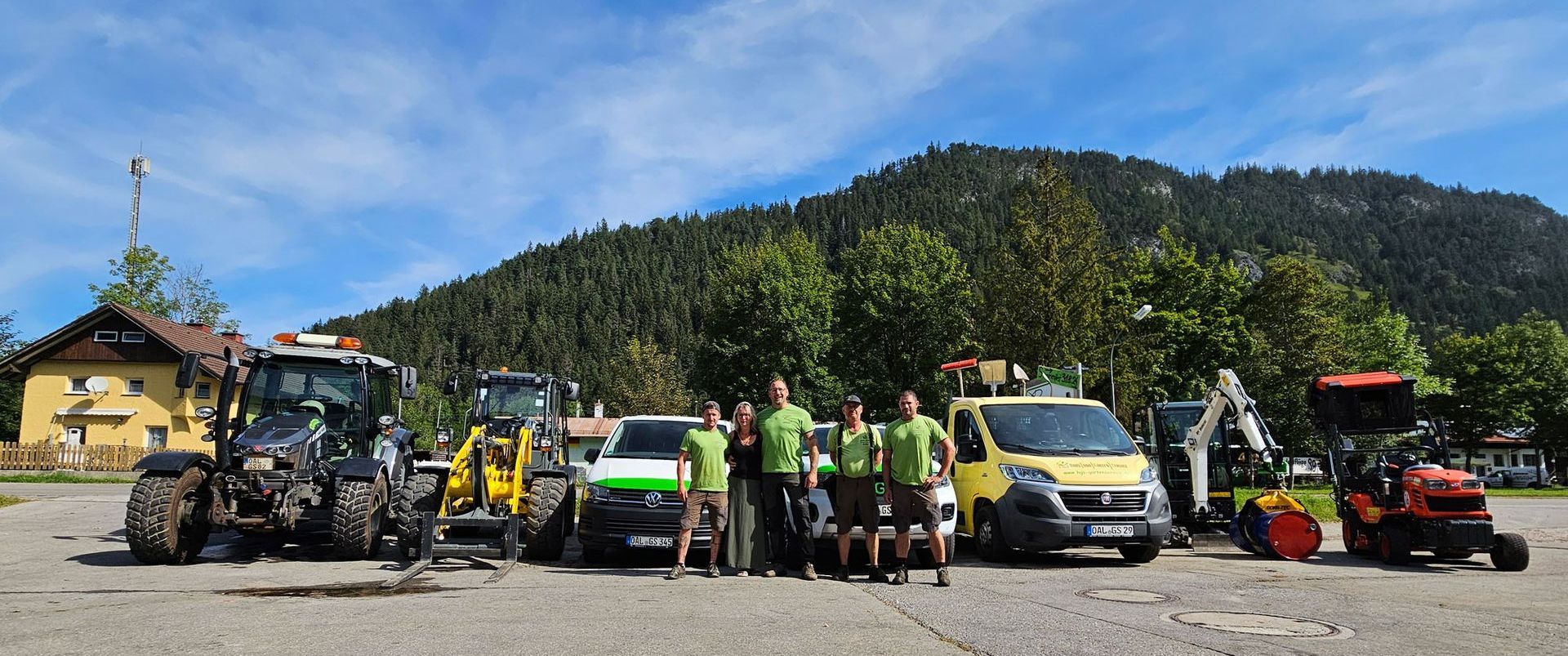 Eine Gruppe von Menschen steht vor einer Reihe von Traktoren.