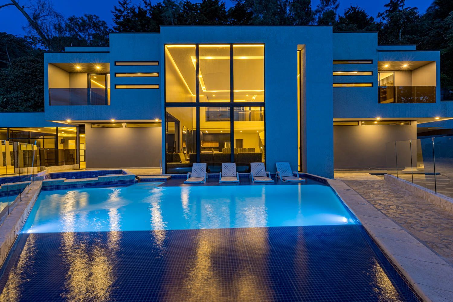 A large house with a large swimming pool in front of it