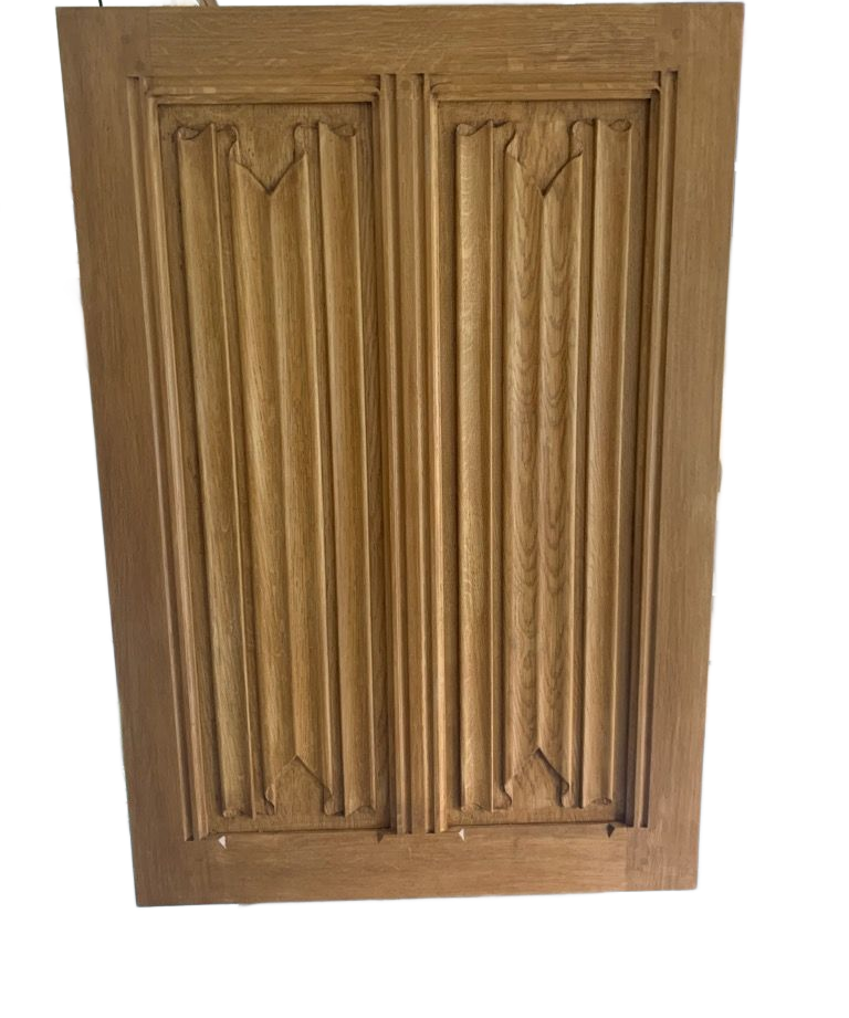 Panneau de porte d’armoire en bois avec des lattes verticales sculptées et des moulures décoratives.