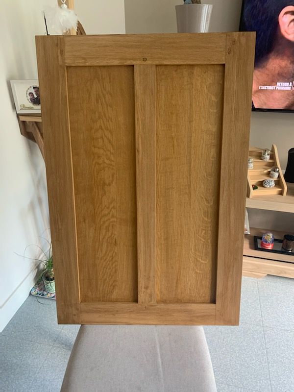 Porte d’armoire en bois à deux panneaux encastrés, vue de face à l’intérieur.