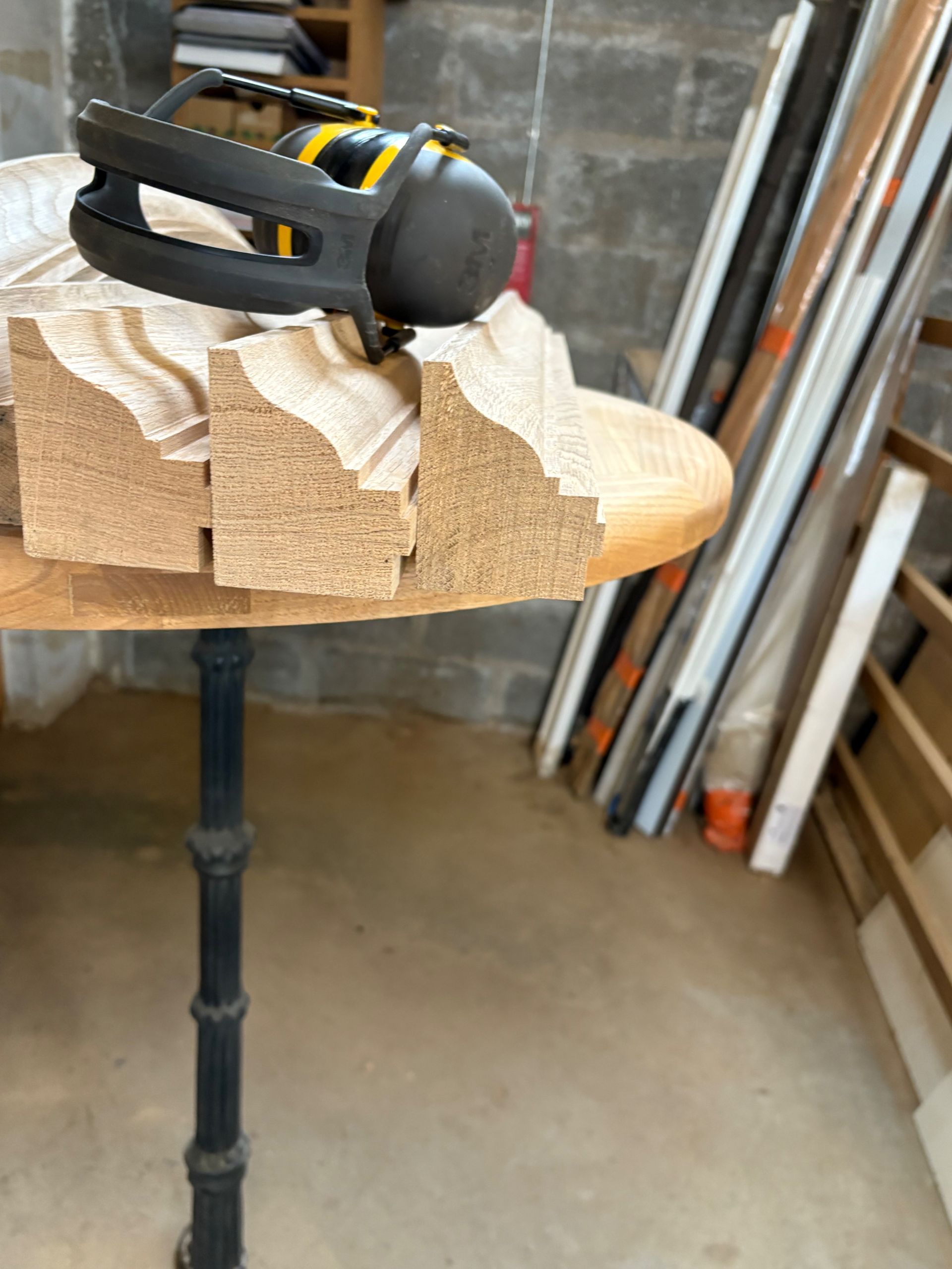 Outil sans fil noir et jaune posé sur des blocs de bois sculptés dans un atelier.