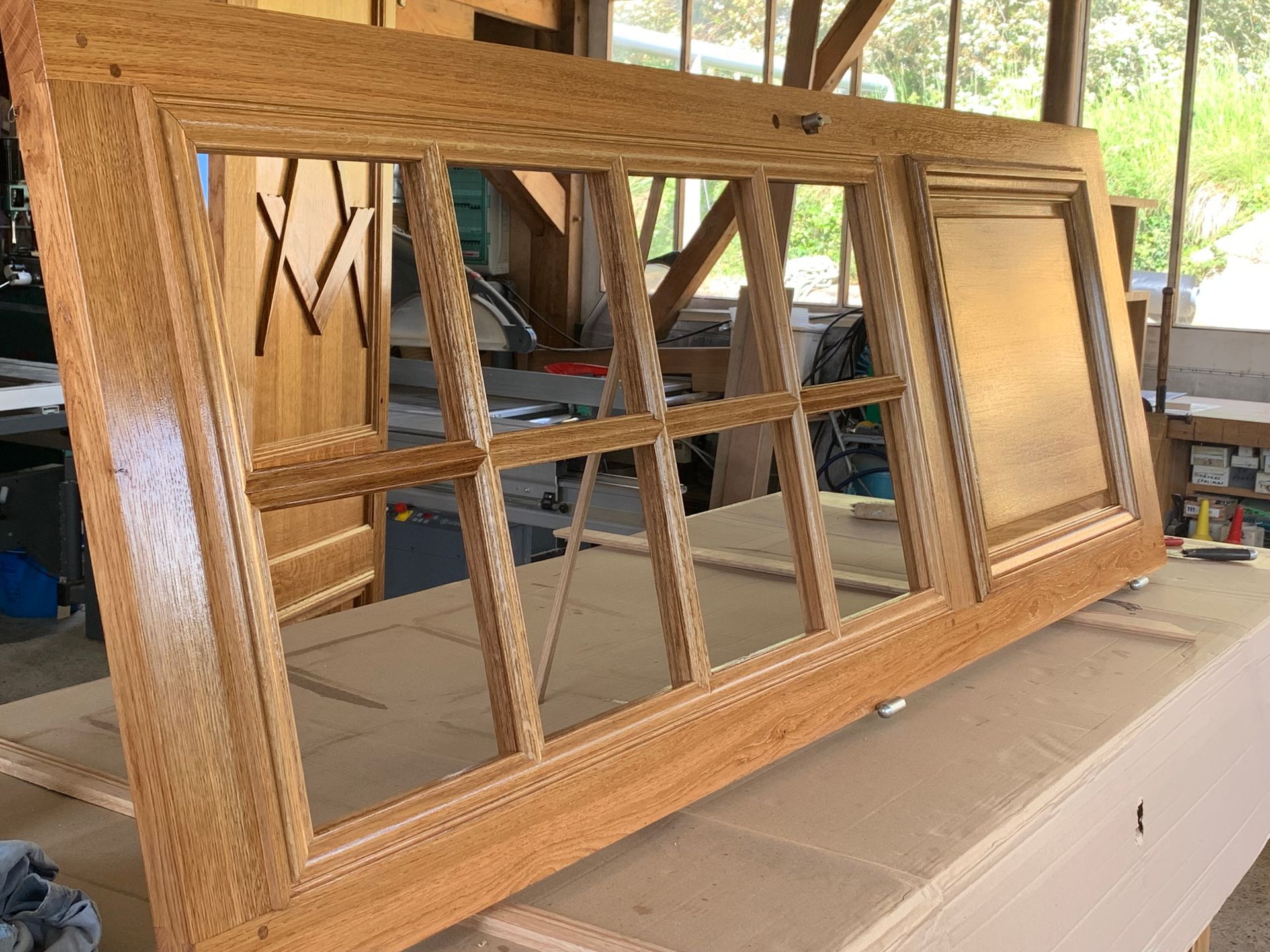 Cadre de porte en bois, appuyé contre un établi dans un atelier.