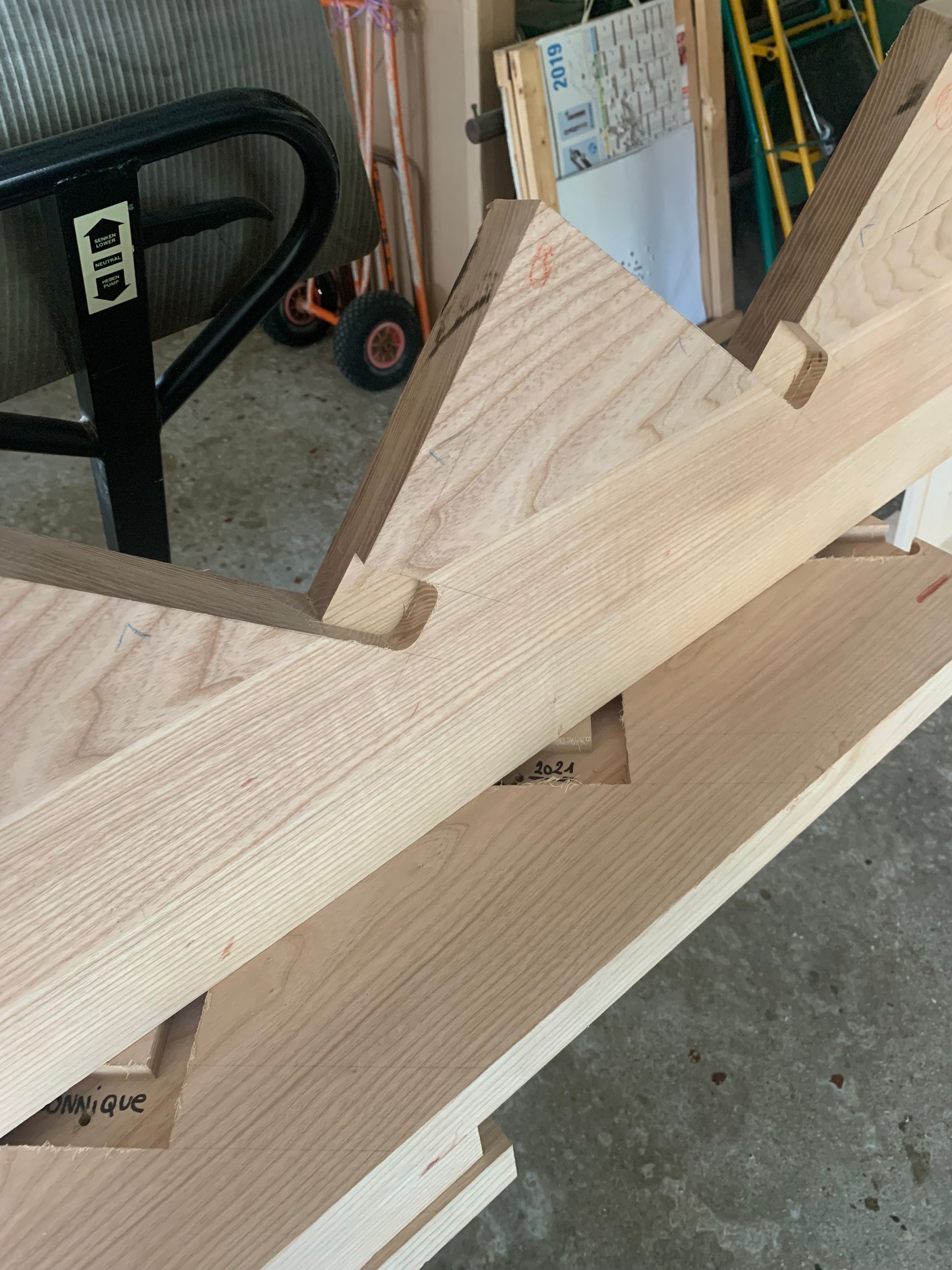 Des pièces de bois posées sur un établi dans un atelier.