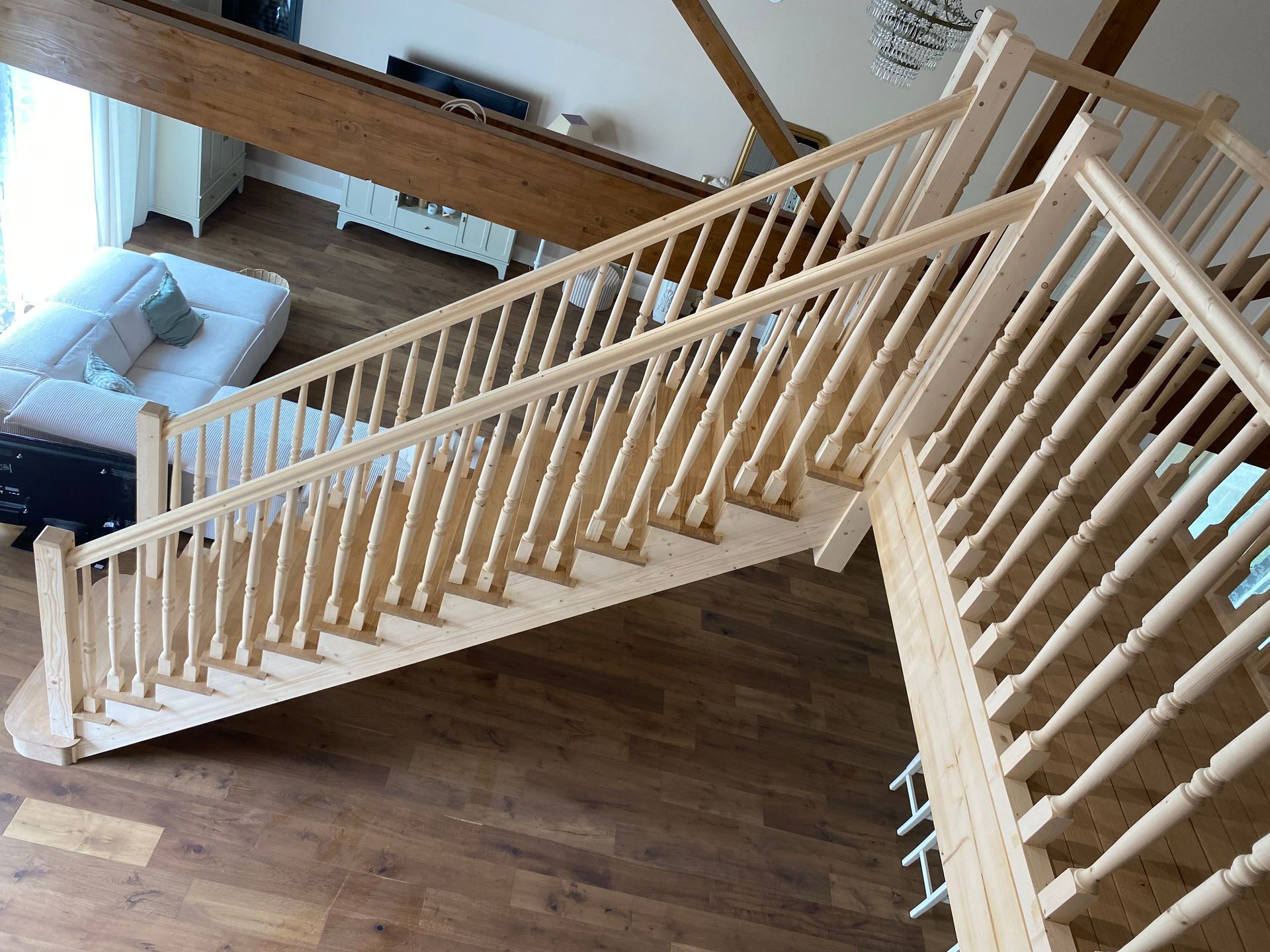 Escalier en bois avec des rampes de couleur claire dans l’intérieur moderne d’une maison, vu d’en haut.