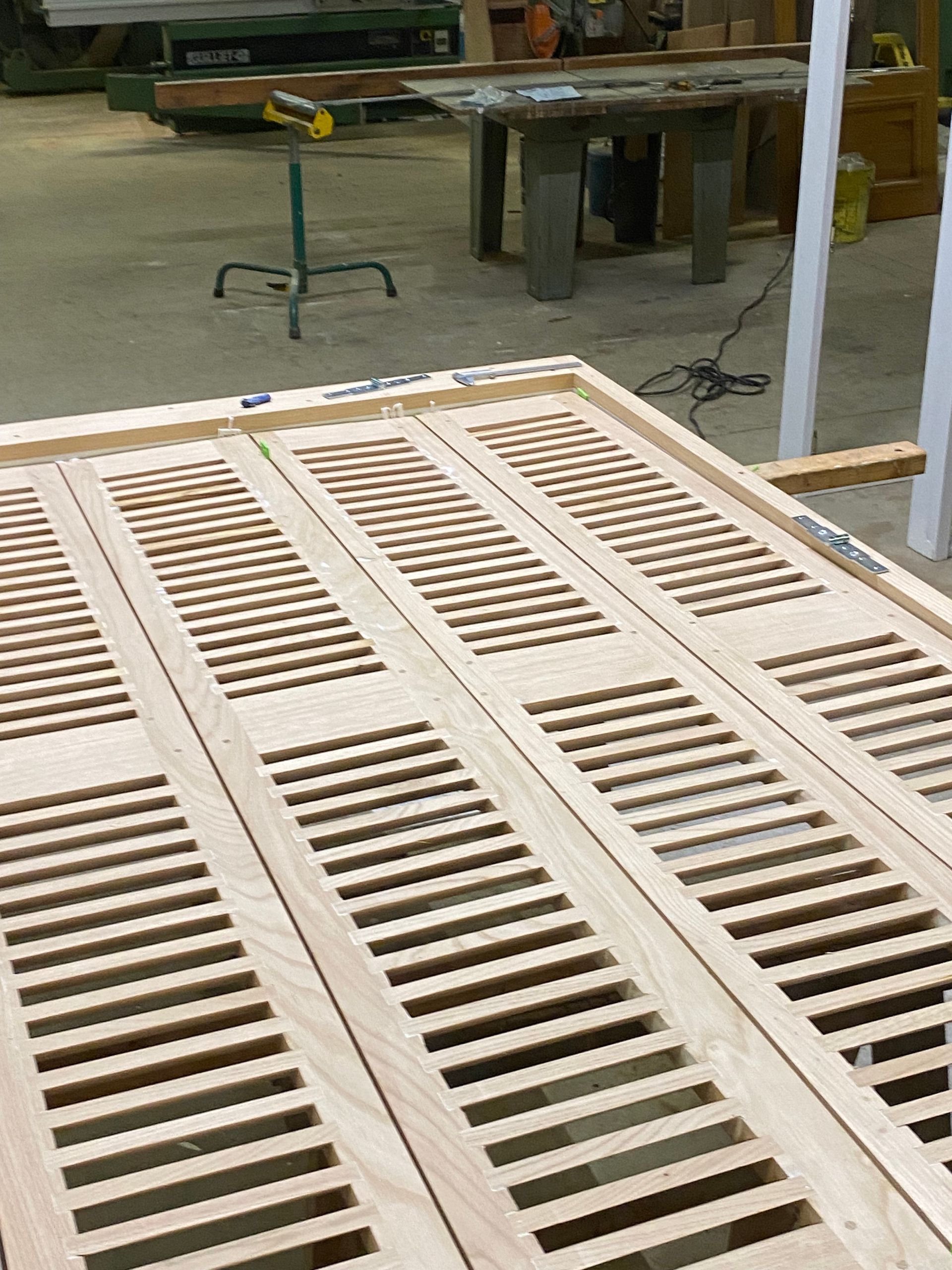 Panneaux à lattes en bois posés sur un établi dans un atelier.