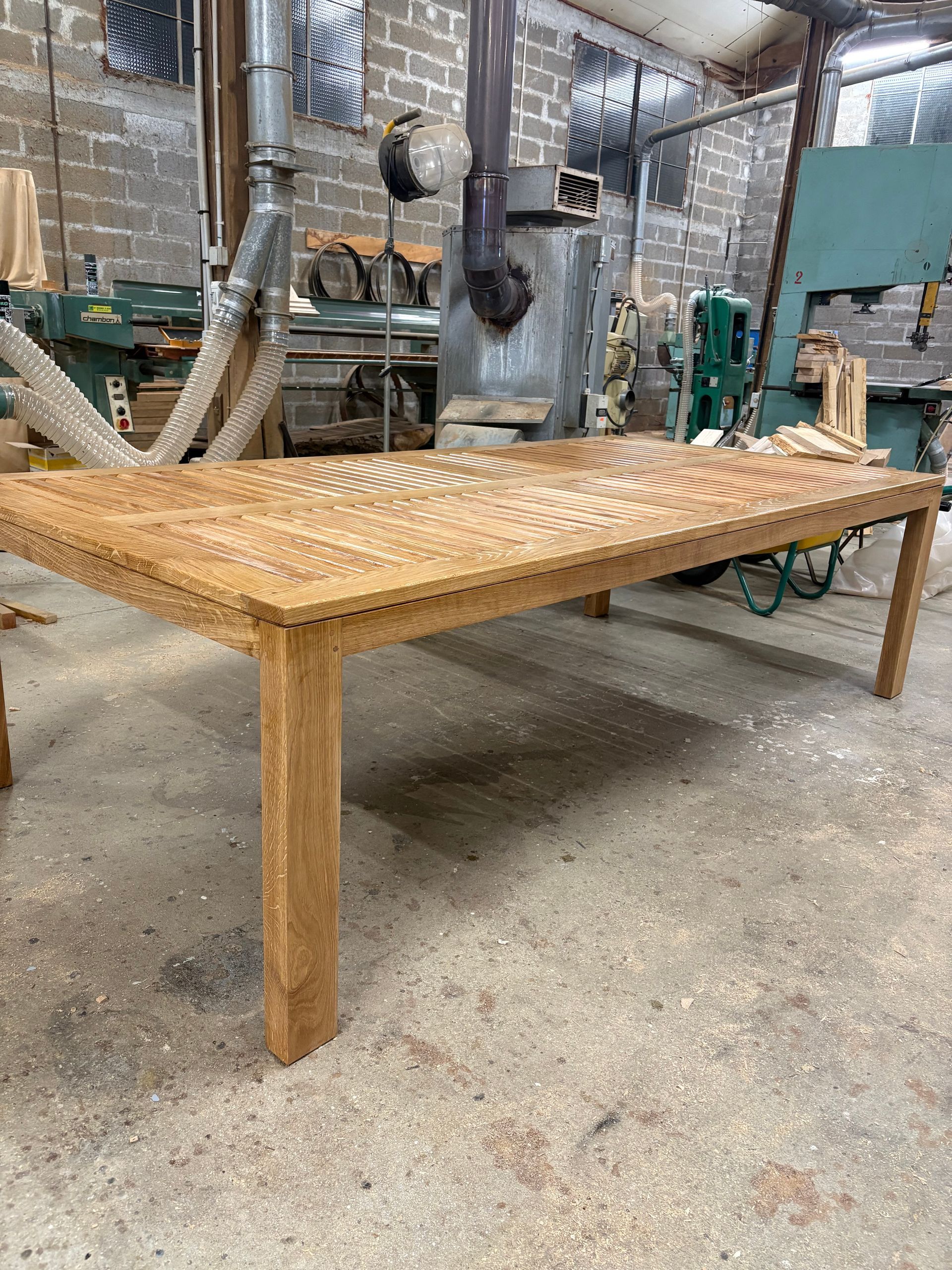 Table à manger avec pieds en bois dans un atelier industriel.