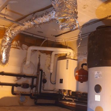 Una habitación con muchas tuberías y un calentador.