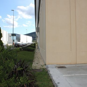 Una vista lateral de un edificio con un estacionamiento frente a él.
