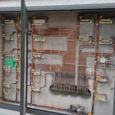 Una pared con muchas tuberías y válvulas.